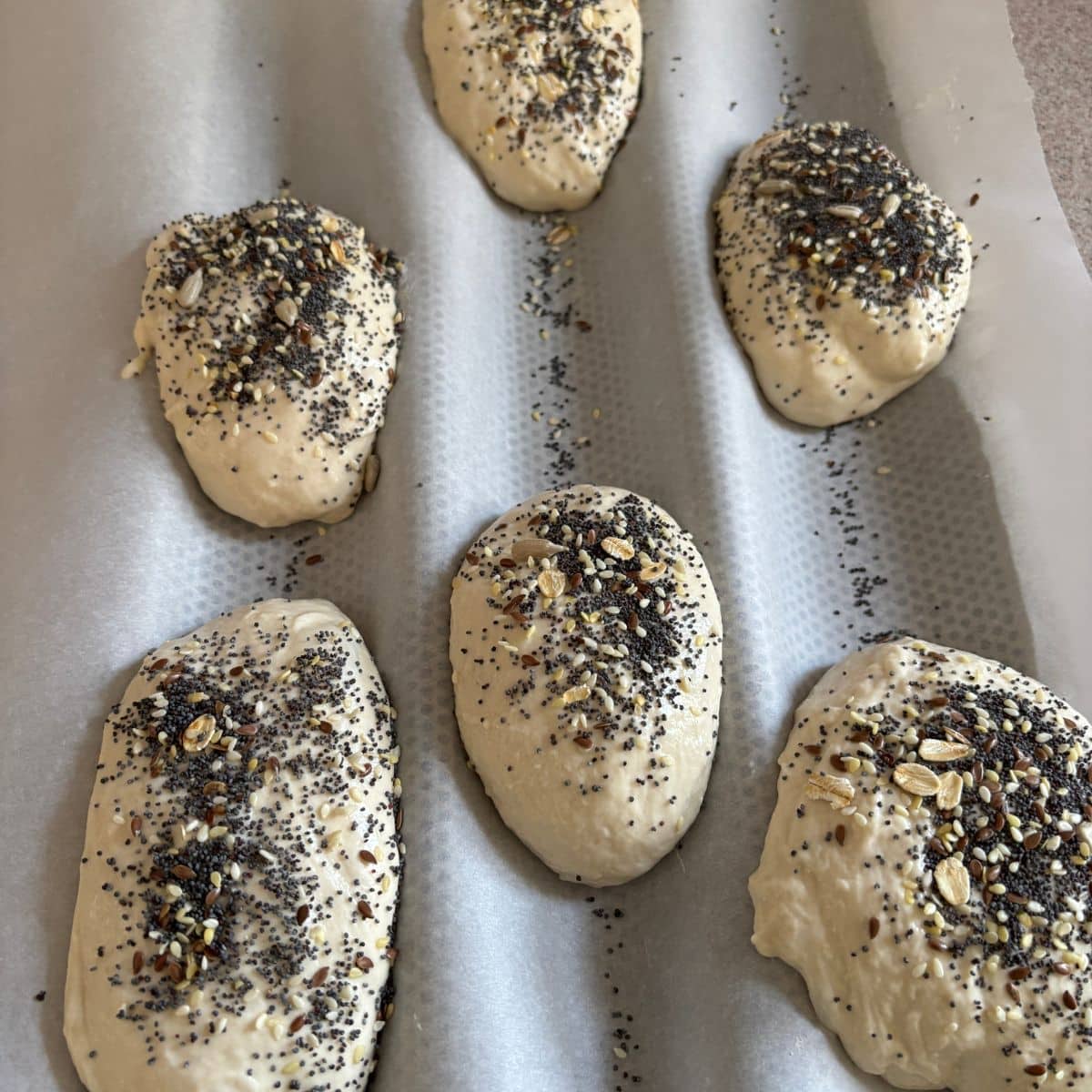 Authentic German Brötchen Dough on a Baguette Tray with parchment paper