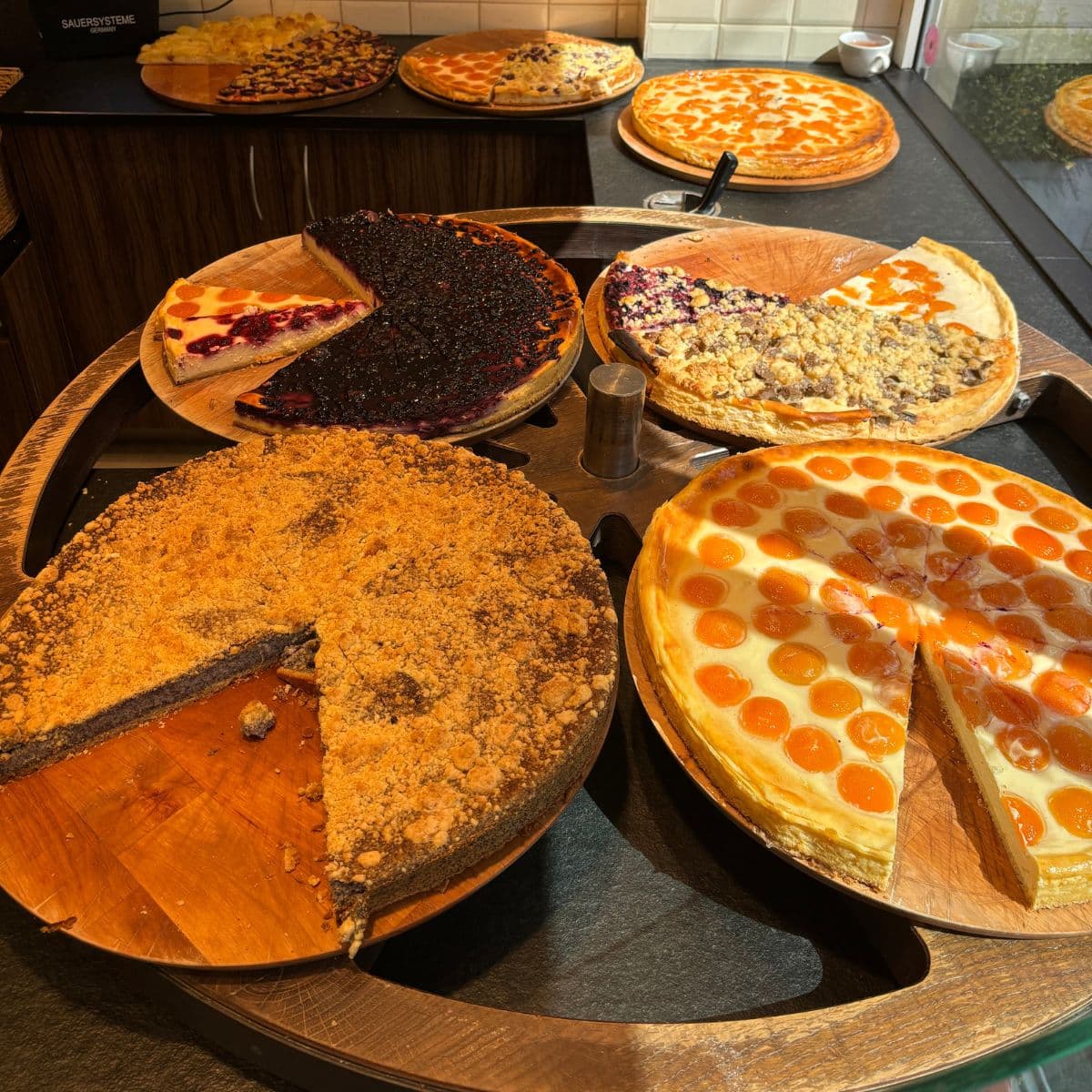 Display of many different German cheesecakes inside a bakery