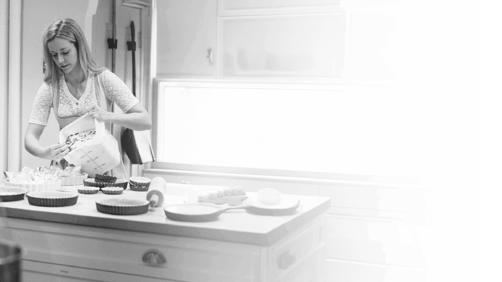 Woman baking pastries in a kitchen.