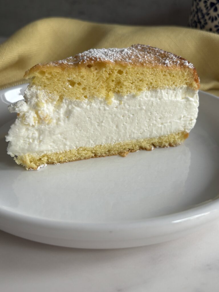 Slice of cream-filled German cheese cake on plate