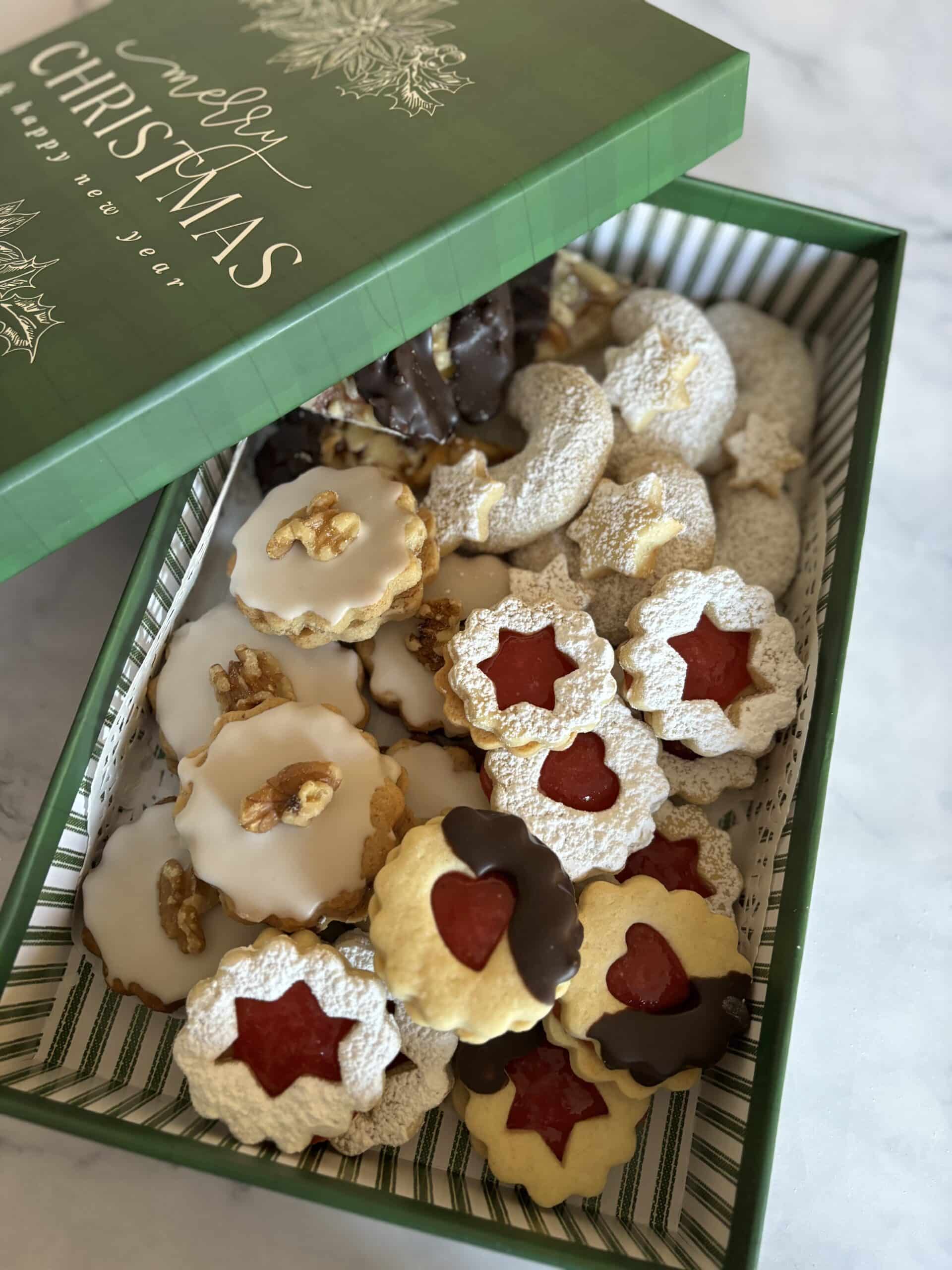 Assorted Christmas cookies in decorative green box.
