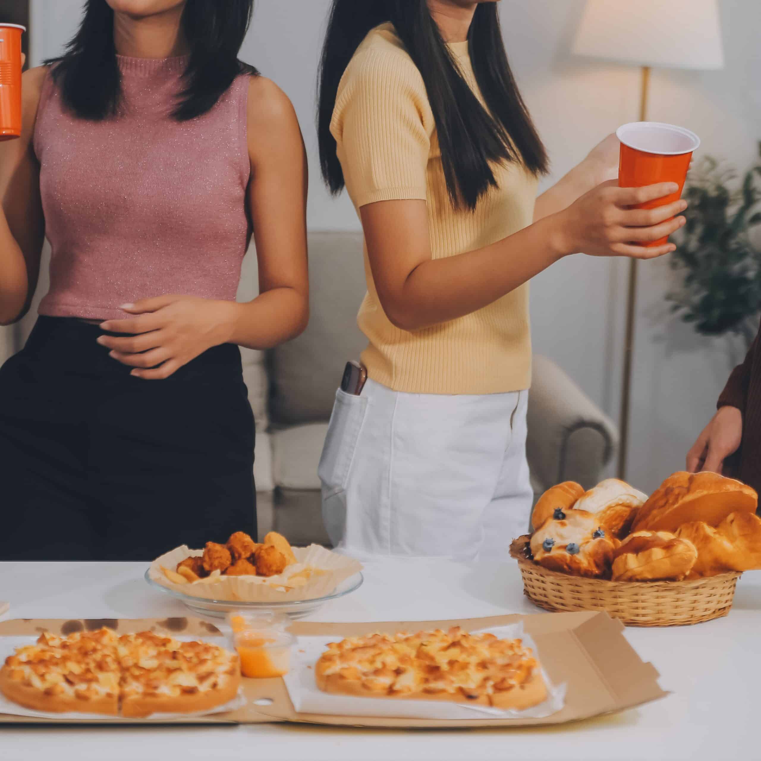 Women enjoying snacks and drinks at home gathering.