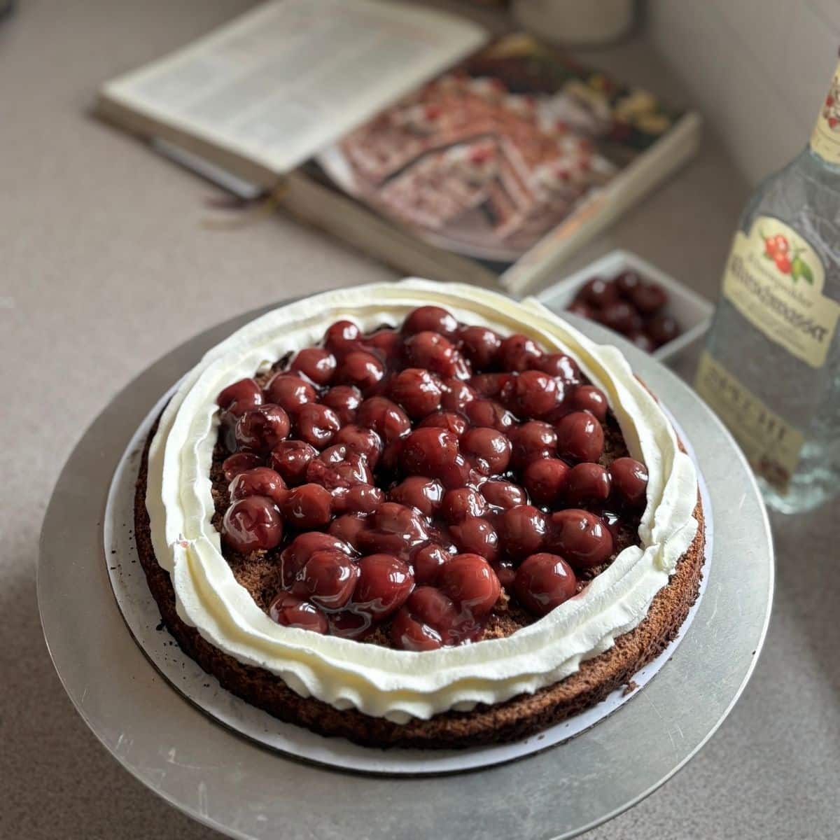 Cherry filling layered inside a German Black Forest cake with piped whipped cream border