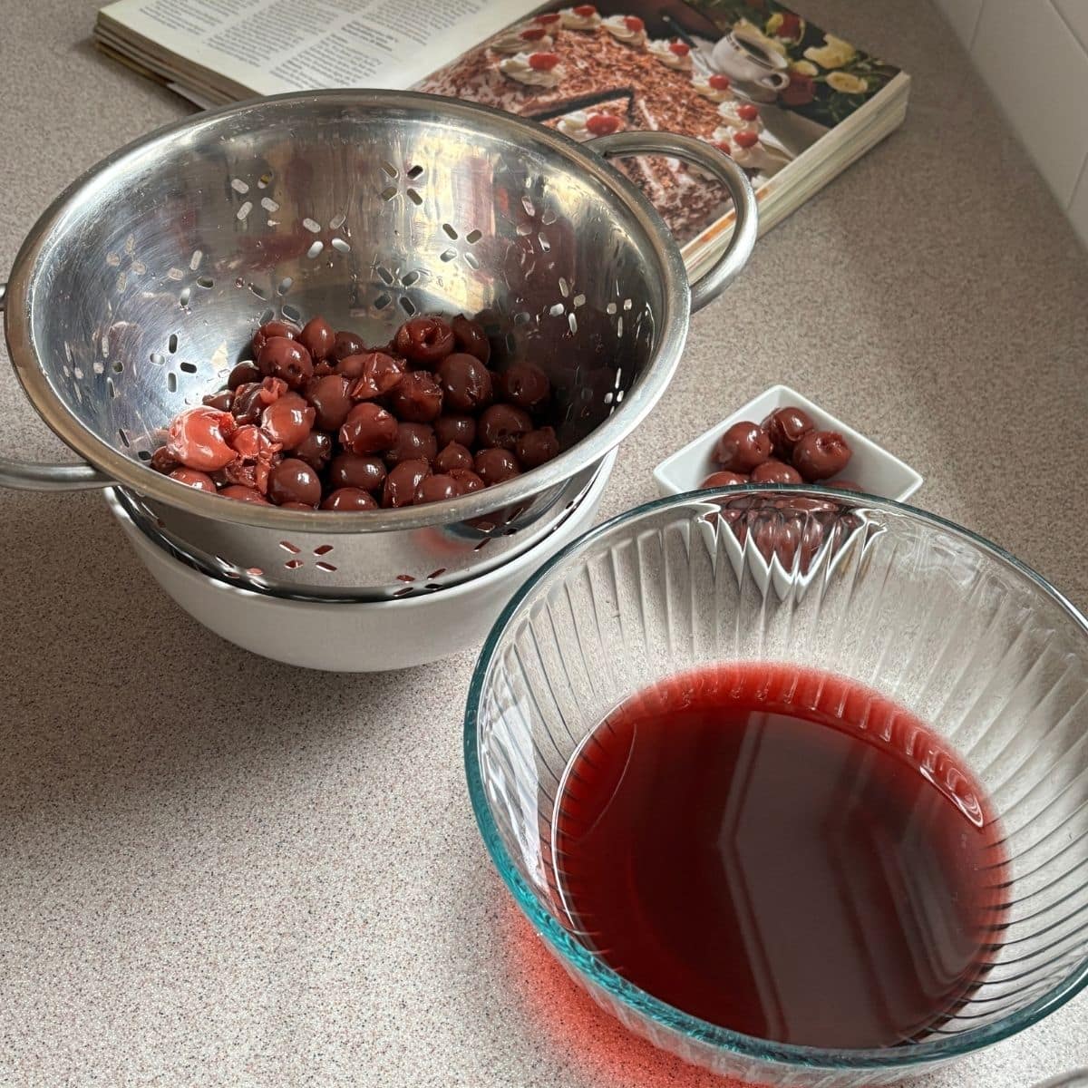 Draining sour cherries and reserving cherry juice for Black Forest cake filling