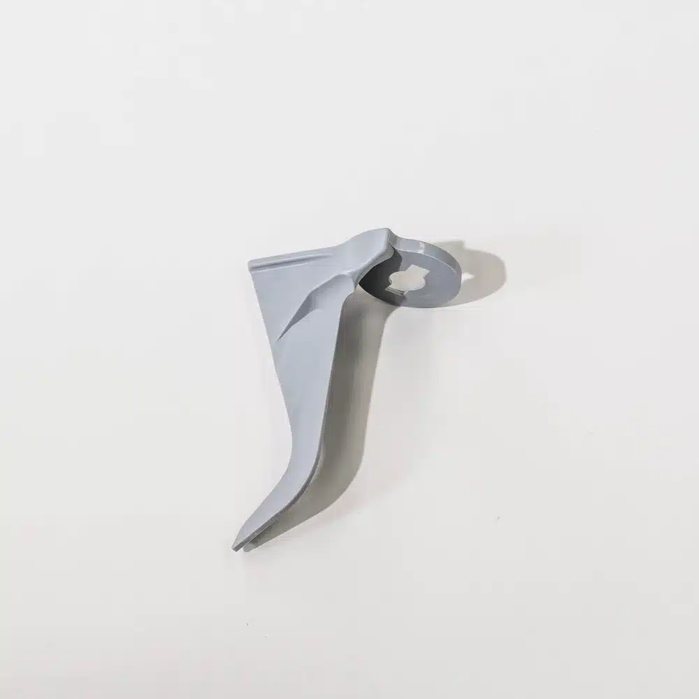 Gray plastic sewing machine part on white background.