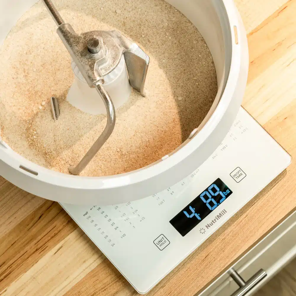 Flour on digital kitchen scale displaying weight.