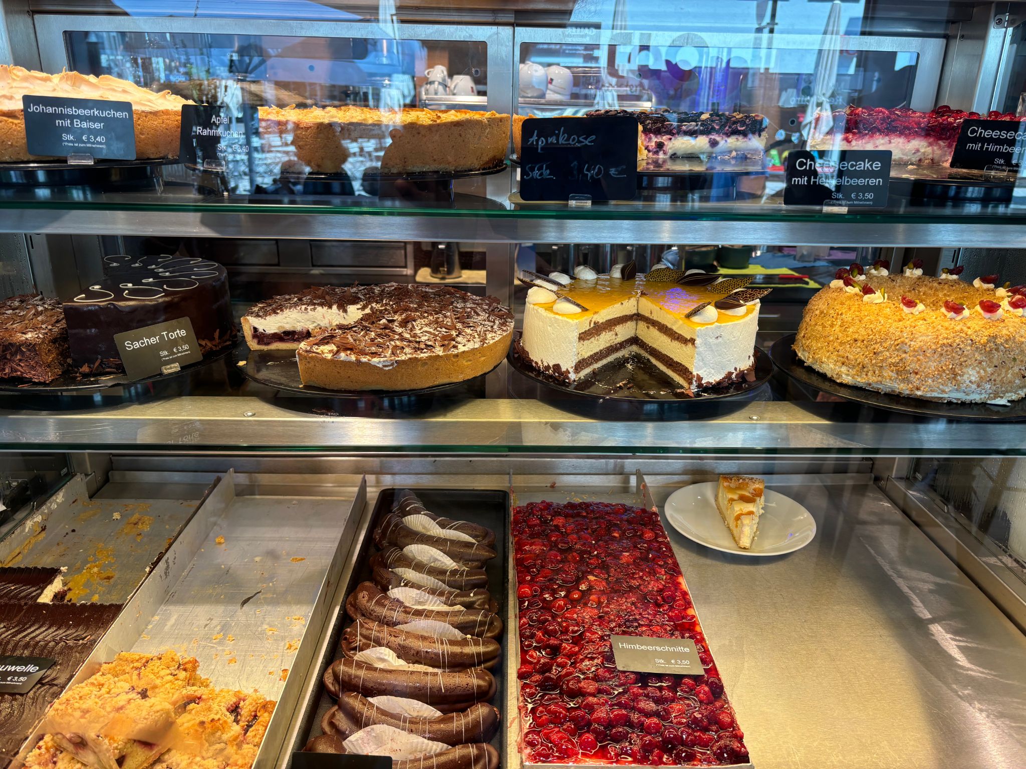 Assorted cakes and pastries in a bakery display.