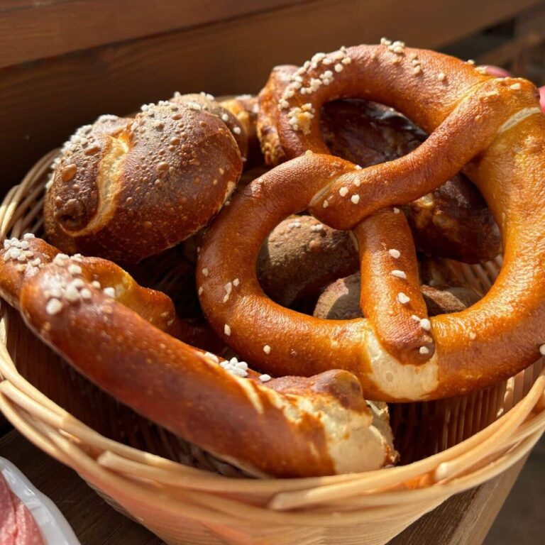 Basket of fresh pretzels on a wooden table.