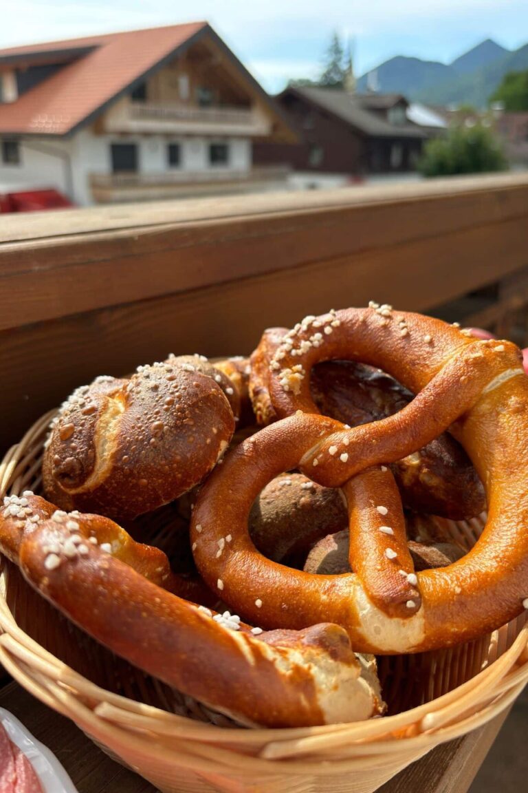 Basket of fresh pretzels on a wooden table.