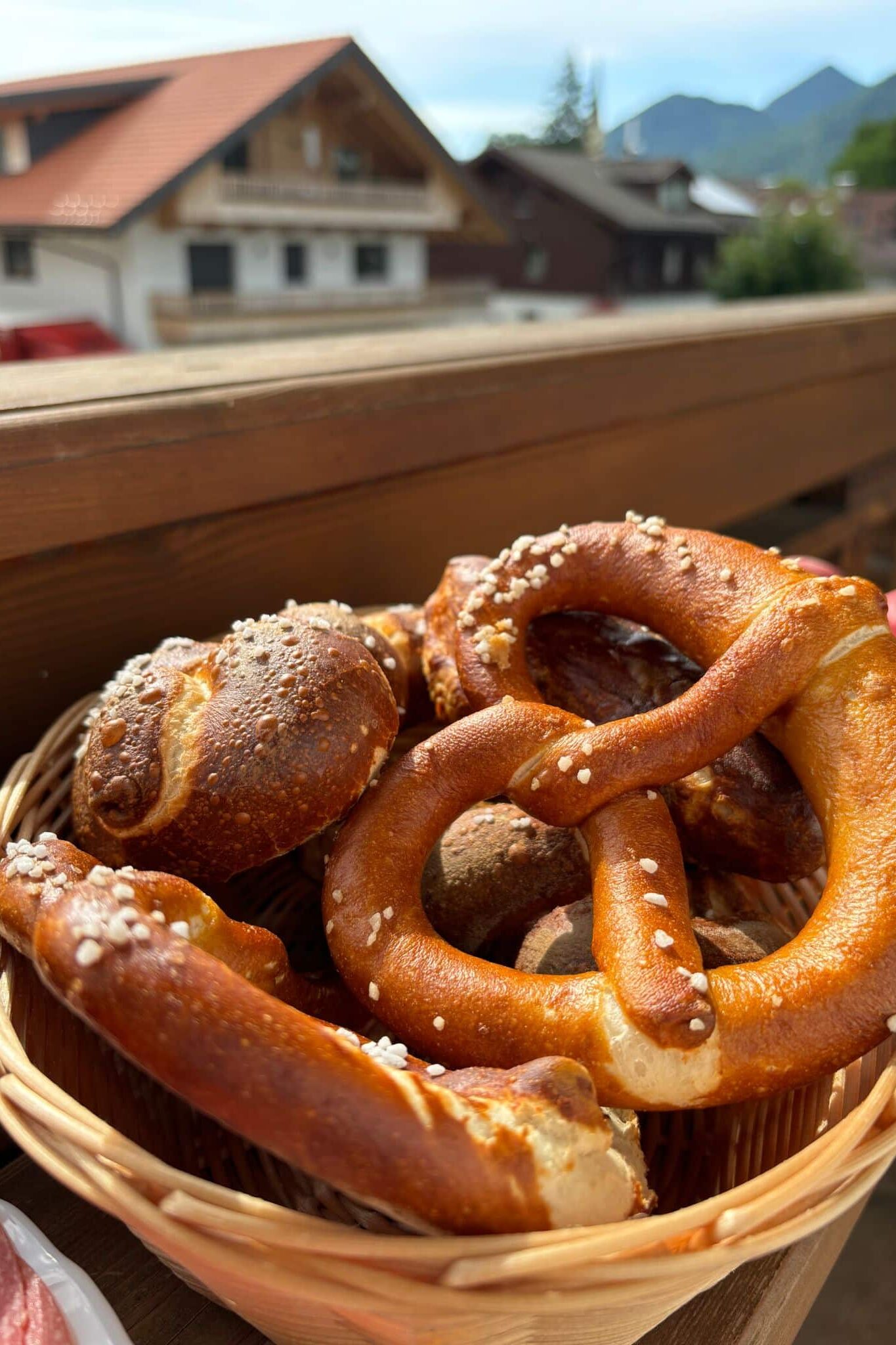 Basket of fresh pretzels on a wooden table.