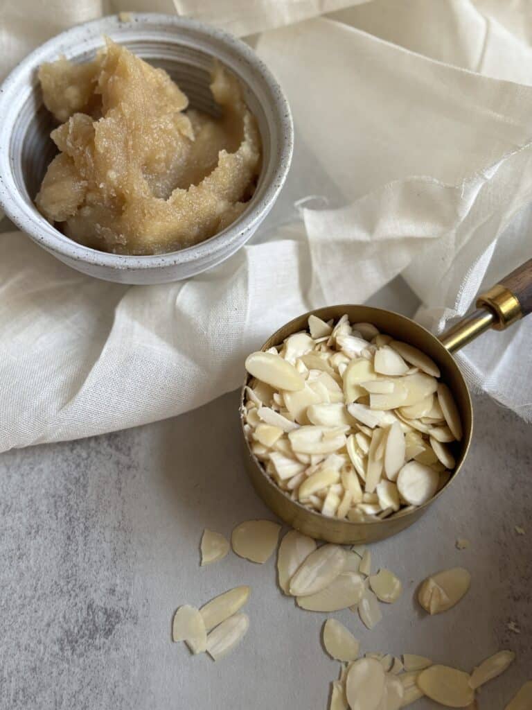 Bowl with paste, cup with sliced almonds.