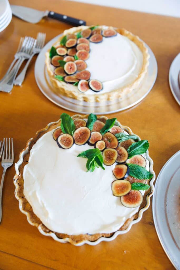 Two fig tarts with whipped cream and mint garnish.