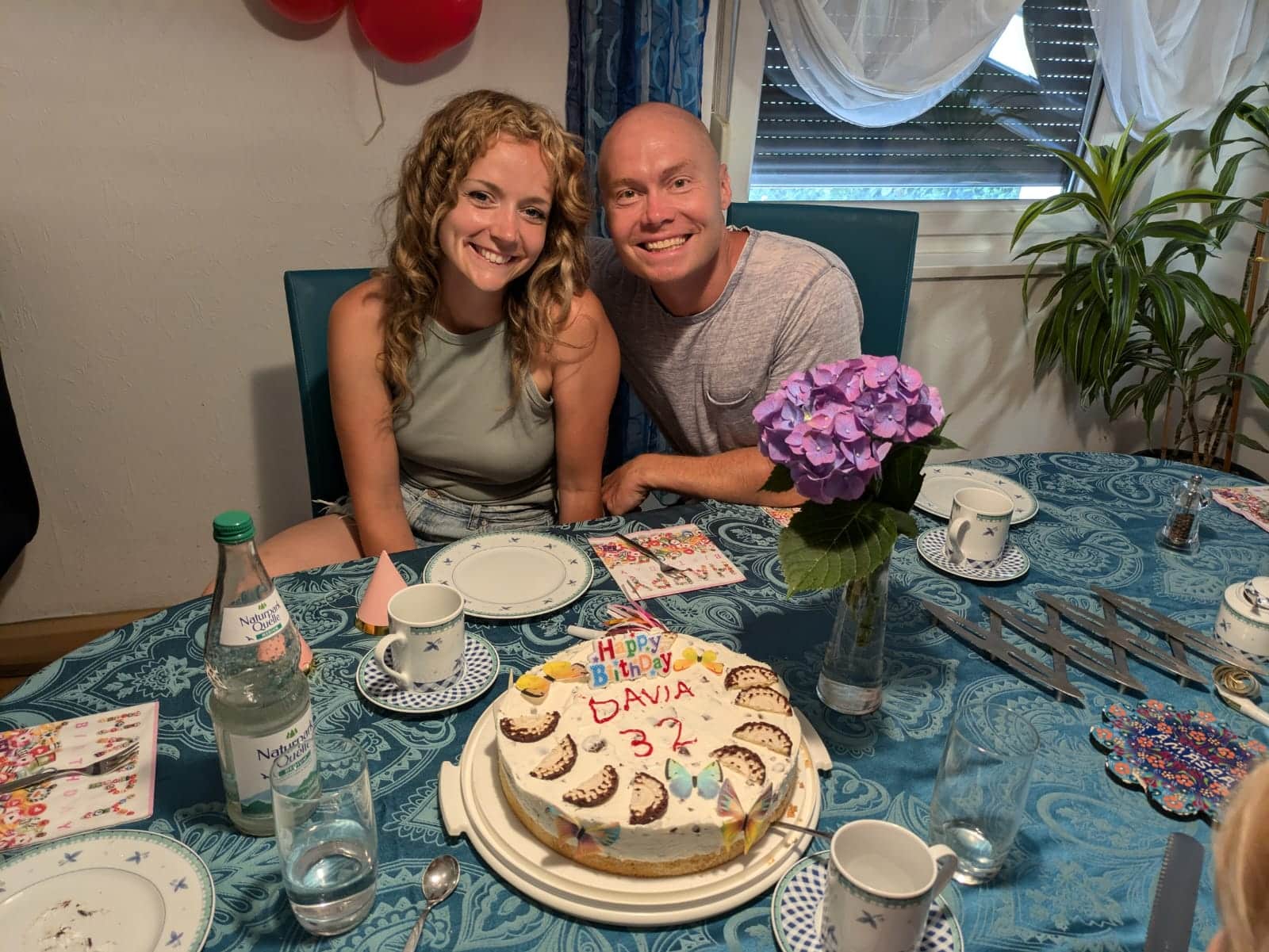 Smiling couple celebrates birthday with cake.