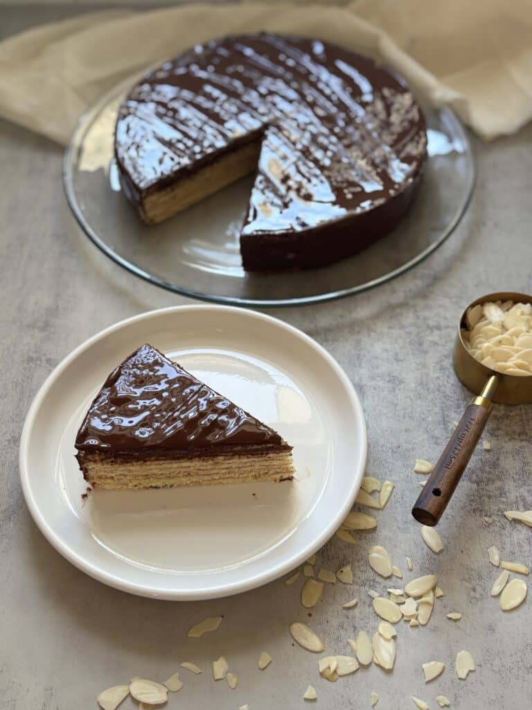 Chocolate-covered layered cake with sliced almonds.
