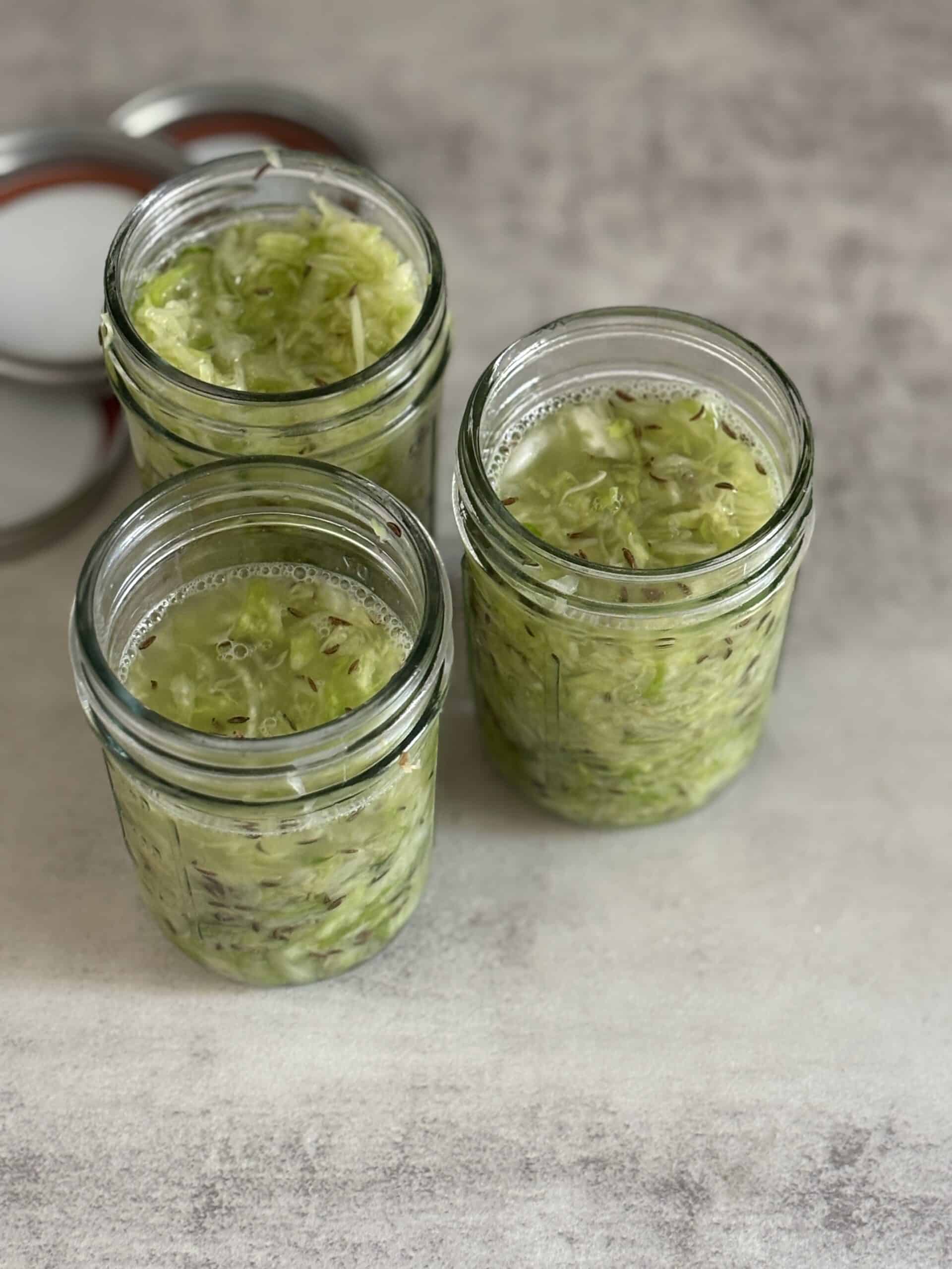 Jars of homemade fermented sauerkraut on table.