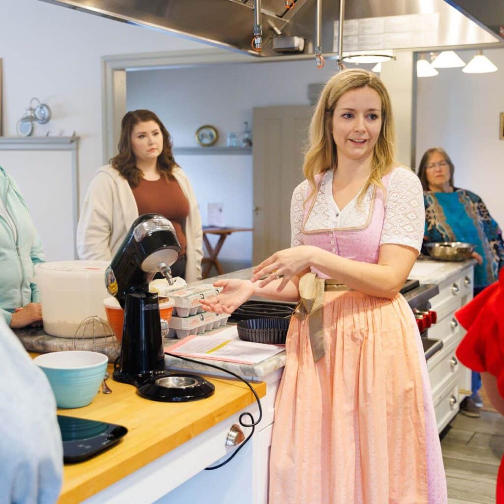 Woman in dirndl teaching a baking class