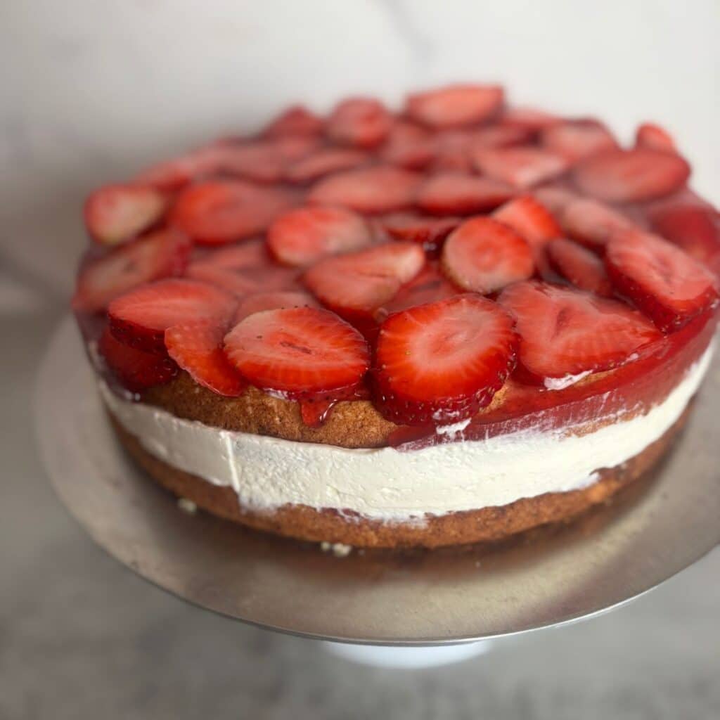 Strawberry mascarpone cake with two sponge layers, creamy filling, and fresh strawberries on top
