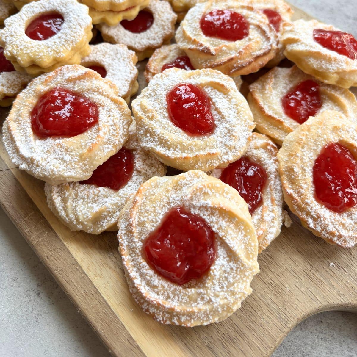 German Marzipan Cookies on wooden board with strawberry jam